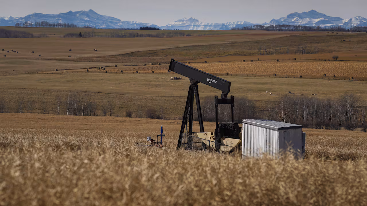 Pumpjack in a field with mountains in the distance